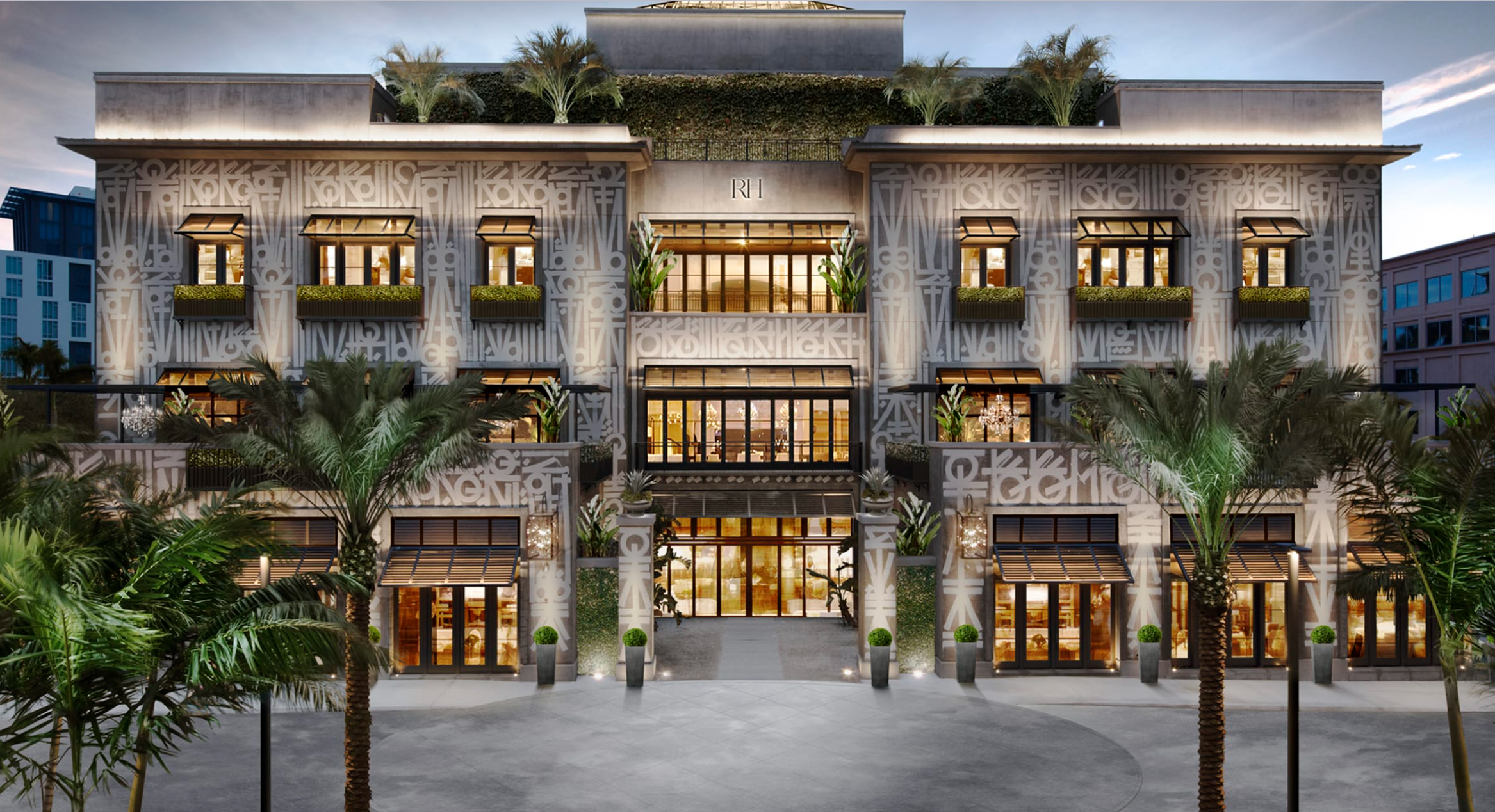Exterior view of RH Gallery luxury retail store featuring grand symmetrical architecture, modern glass facade, classical design elements, and lush greenery including palm trees. Upscale multi-story building with illuminated interior, showcasing Restoration Hardware’s premium home furnishings brand